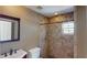 Well-lit bathroom featuring custom tile shower with niche, wood mirror and vanity at 1149 Sedeeva St, Clearwater, FL 33755