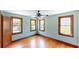 Bedroom featuring refinished hardwood floors, blue walls, and ample natural light at 1149 Sedeeva St, Clearwater, FL 33755