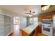 Sunlit kitchen with wood floors, cabinets, stove, dishwasher, and windows at 1149 Sedeeva St, Clearwater, FL 33755