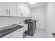 Modern laundry room with white cabinets and new appliances at 11600 Tradewinds Blvd, Largo, FL 33773