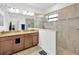 Modern bathroom with double vanity, granite countertop, walk-in shower, and tile flooring at 11926 Cinnamon Fern Dr, Riverview, FL 33579