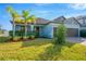 Light blue single-story home with brown double garage and landscaped yard at 11926 Cinnamon Fern Dr, Riverview, FL 33579