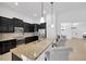 Modern kitchen featuring dark wood cabinets, granite countertops, stainless steel appliances, and a breakfast bar at 11926 Cinnamon Fern Dr, Riverview, FL 33579