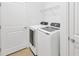 Well-lit laundry room with modern, white washer and dryer, and storage shelving for convenience at 11926 Cinnamon Fern Dr, Riverview, FL 33579