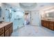 Bright bathroom featuring double vanity sinks, a glass door shower, and white marble tile flooring at 1860 N Fort Harrison Ave # 104, Clearwater, FL 33755