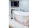 Modern bathroom with a sleek, freestanding bathtub with a floor mounted faucet and marble style tiles at 1860 N Fort Harrison Ave # 104, Clearwater, FL 33755