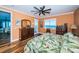 Bright bedroom with hardwood floors, ceiling fan, a balcony overlooking the water, and a green leaf patterned comforter at 1860 N Fort Harrison Ave # 104, Clearwater, FL 33755