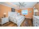 Bright bedroom with hardwood floors, ceiling fan, a window with a water view, and a white comforter at 1860 N Fort Harrison Ave # 104, Clearwater, FL 33755