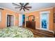 Well lit bedroom with hardwood floors, a ceiling fan, a balcony overlooking the water, and a green leaf patterned comforter at 1860 N Fort Harrison Ave # 104, Clearwater, FL 33755