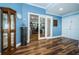 Hallway featuring wood-look floors, glass doors leading to an office, and decorative elements at 1860 N Fort Harrison Ave # 104, Clearwater, FL 33755