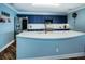 Kitchen with island and breakfast bar, custom navy cabinets, and modern appliances at 1860 N Fort Harrison Ave # 104, Clearwater, FL 33755