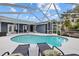 Inviting pool area with screened enclosure, lounge chairs, and lush landscaping at 1932 Brainerd Ct, Lutz, FL 33549