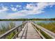 Picturesque view from a wooden dock extending over a serene lake, showcasing the clear blue sky at 2256 Philippine Dr # 56, Clearwater, FL 33763