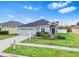 One-story house with gray siding, two-car garage, and landscaped yard at 4005 Langdrum Dr, Wesley Chapel, FL 33543