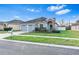 One-story house with gray siding, two-car garage, and landscaped yard at 4005 Langdrum Dr, Wesley Chapel, FL 33543