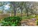 The landscaped backyard features mature trees, a privacy wall, and tropical landscaping at 6325 Stone River Rd, Bradenton, FL 34203
