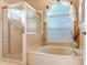 Bathroom featuring glass enclosed shower, tub, and window that provides natural light at 6325 Stone River Rd, Bradenton, FL 34203