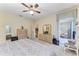Comfortable bedroom features neutral carpet, ceiling fan, and access to lanai at 6325 Stone River Rd, Bradenton, FL 34203