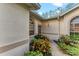 Close up of front entrance with colorful, tropical landscaping and stucco facade at 6325 Stone River Rd, Bradenton, FL 34203