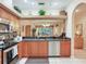 Well-lit kitchen with granite countertops, wooden cabinets, stainless-steel appliances, and an open design to the living area at 6325 Stone River Rd, Bradenton, FL 34203