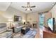 Cozy living room features wood floors, ceiling fan, comfortable seating, and access to patio at 6325 Stone River Rd, Bradenton, FL 34203