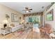 Bright living room features hardwood floors, ceiling fan, sliding glass doors to outdoor patio at 6325 Stone River Rd, Bradenton, FL 34203