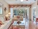 Bright living room featuring hardwood floors, comfortable seating, and a sliding glass door to a patio at 6325 Stone River Rd, Bradenton, FL 34203