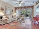 Bright living room with hardwood floors, ceiling fan, and access to outdoor patio at 6325 Stone River Rd, Bradenton, FL 34203