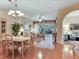 Bright living room featuring hardwood floors, chandelier, and sliding door to patio at 6325 Stone River Rd, Bradenton, FL 34203
