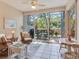 Enclosed patio featuring tile floors, ceiling fan and seating with an outdoor view at 6325 Stone River Rd, Bradenton, FL 34203