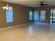 Spacious living room with tile flooring, large windows, and a ceiling fan at 7009 Makers Way, Apollo Beach, FL 33572