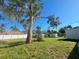Large backyard with grass and mature trees at 735 Bertrend St, Englewood, FL 34223
