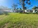 Large backyard with grassy area and trees at 735 Bertrend St, Englewood, FL 34223