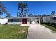 Newly renovated home with red front door and landscaped yard at 735 Bertrend St, Englewood, FL 34223