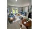 Bright living room with gray sofas, coffee table, and access to backyard at 735 Bertrend St, Englewood, FL 34223