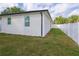The home features a well-maintained backyard, enclosed by a white fence, offering a private outdoor space at 8317 N Ogontz Ave, Tampa, FL 33604