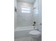 Bathroom featuring white tiled walls, new tub, and a shower with a matte black shower head at 8317 N Ogontz Ave, Tampa, FL 33604