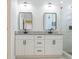 Bathroom featuring double sink with granite countertop and modern shower with glass door at 8317 N Ogontz Ave, Tampa, FL 33604