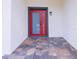 Inviting entryway showcasing a red front door, stone tile floor and modern architectural details at 8317 N Ogontz Ave, Tampa, FL 33604