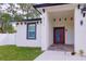 Inviting entryway showcasing a red front door, stone tile floor and modern architectural details at 8317 N Ogontz Ave, Tampa, FL 33604