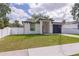 Charming home featuring a gray garage door, red front door and well-maintained green lawn at 8317 N Ogontz Ave, Tampa, FL 33604