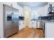 Bright kitchen features stainless steel refrigerator and appliances, white cabinetry, and wood-look flooring at 8317 N Ogontz Ave, Tampa, FL 33604
