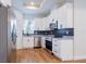 Modern kitchen with white cabinets, stainless steel appliances, granite countertops, and stylish backsplash at 8317 N Ogontz Ave, Tampa, FL 33604