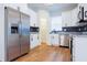 Bright kitchen features stainless steel refrigerator and appliances, white cabinetry, and wood-look flooring at 8317 N Ogontz Ave, Tampa, FL 33604