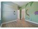 Bedroom with animal mural, wood-look floors, and shelving at 13584 Old Creek Ct, Parrish, FL 34219