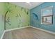 Bedroom with playful animal mural and wood-look floors at 13584 Old Creek Ct, Parrish, FL 34219