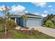 One-story home with blue exterior, two-car garage, and walkway at 13584 Old Creek Ct, Parrish, FL 34219