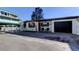 White house with black garage door, and small front yard at 141 94Th Ave, Treasure Island, FL 33706