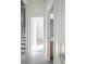 Light-filled hallway with tile flooring and access to bedrooms and stairs at 3602 Juneberry Dr, Wesley Chapel, FL 33543