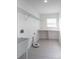 Bright laundry room with utility sink, shelving, and tile floor at 3602 Juneberry Dr, Wesley Chapel, FL 33543